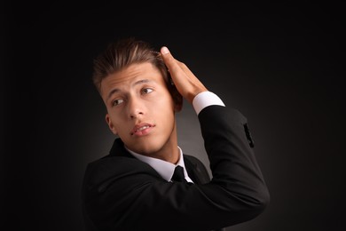 Photo of Confident young man with stylish haircut on black background