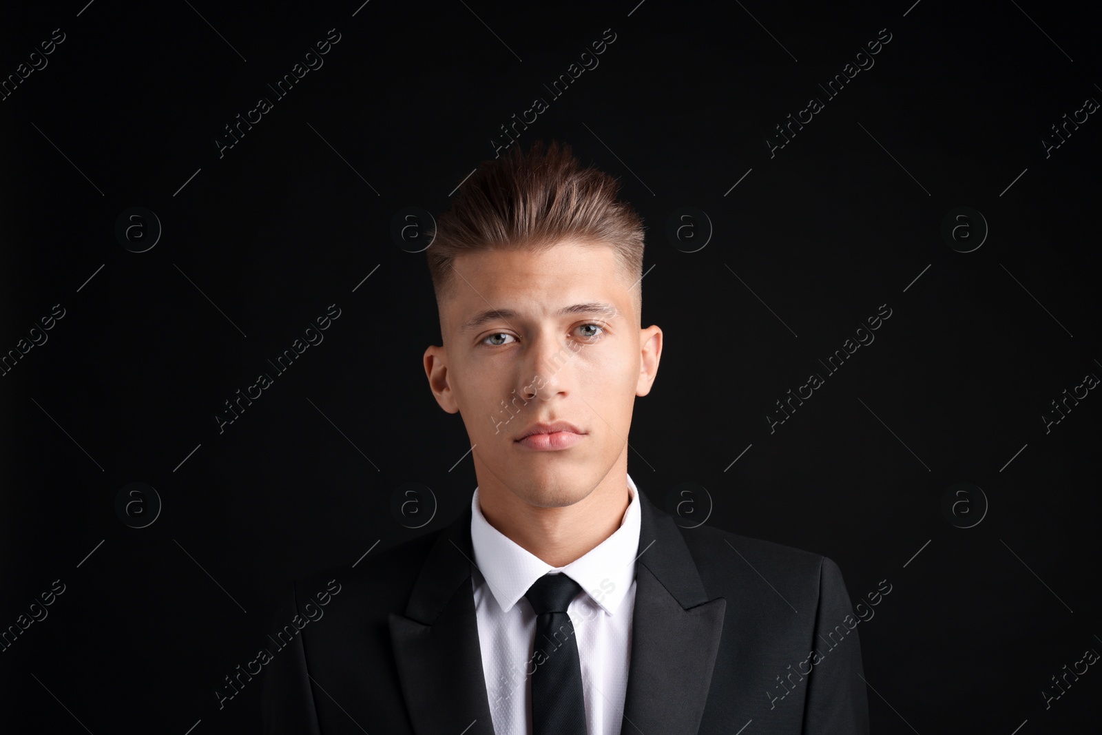 Photo of Confident young man with stylish haircut on black background