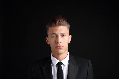 Photo of Confident young man with stylish haircut on black background