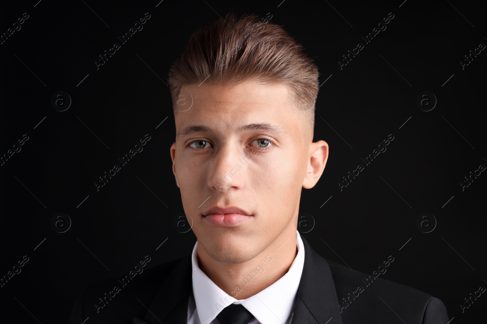 Photo of Confident young man with stylish haircut on black background