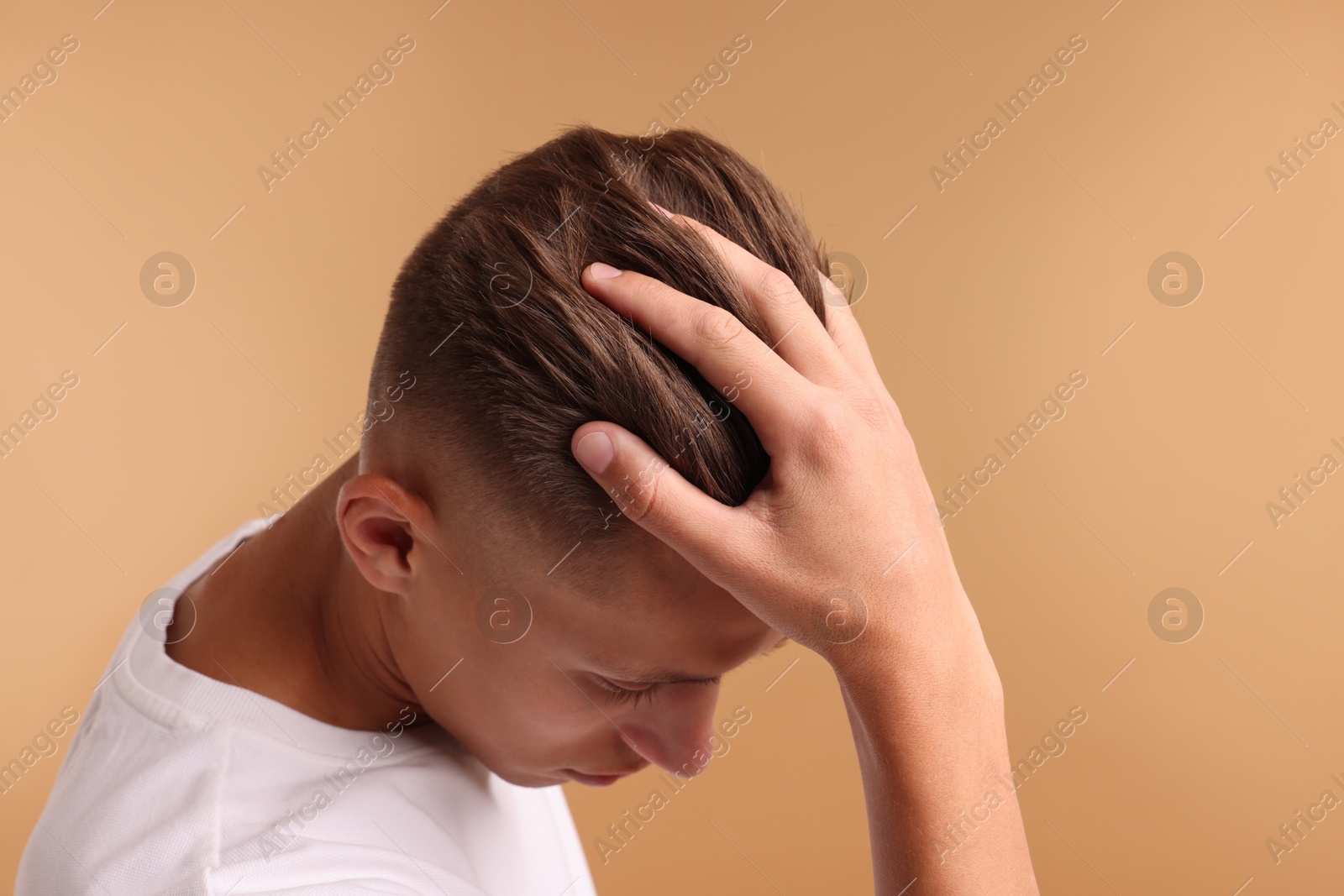 Photo of Young man with stylish haircut on light brown background