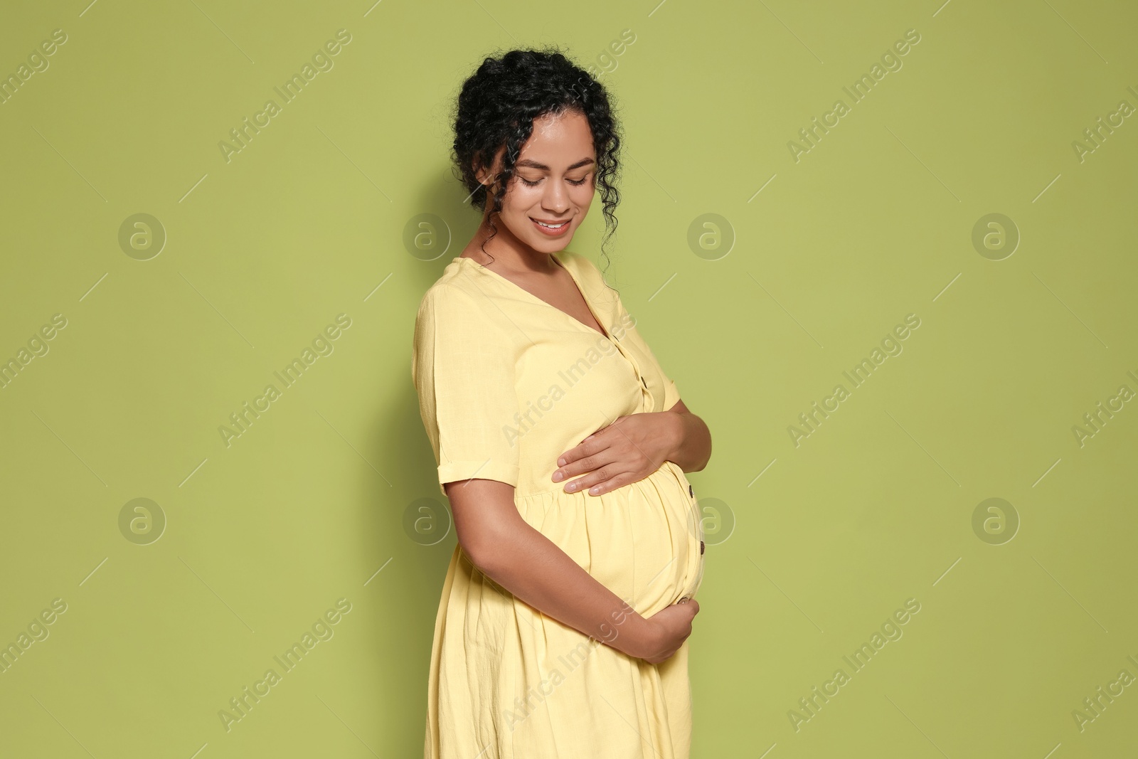 Photo of Portrait of beautiful pregnant woman on green background