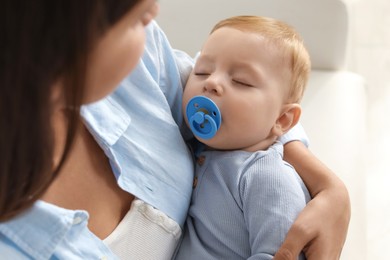 Photo of Mother with her sleeping baby indoors, closeup