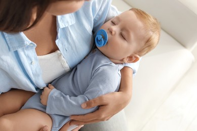 Photo of Mother with her sleeping baby on sofa indoors, closeup