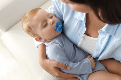 Photo of Mother with her sleeping baby on sofa indoors, closeup