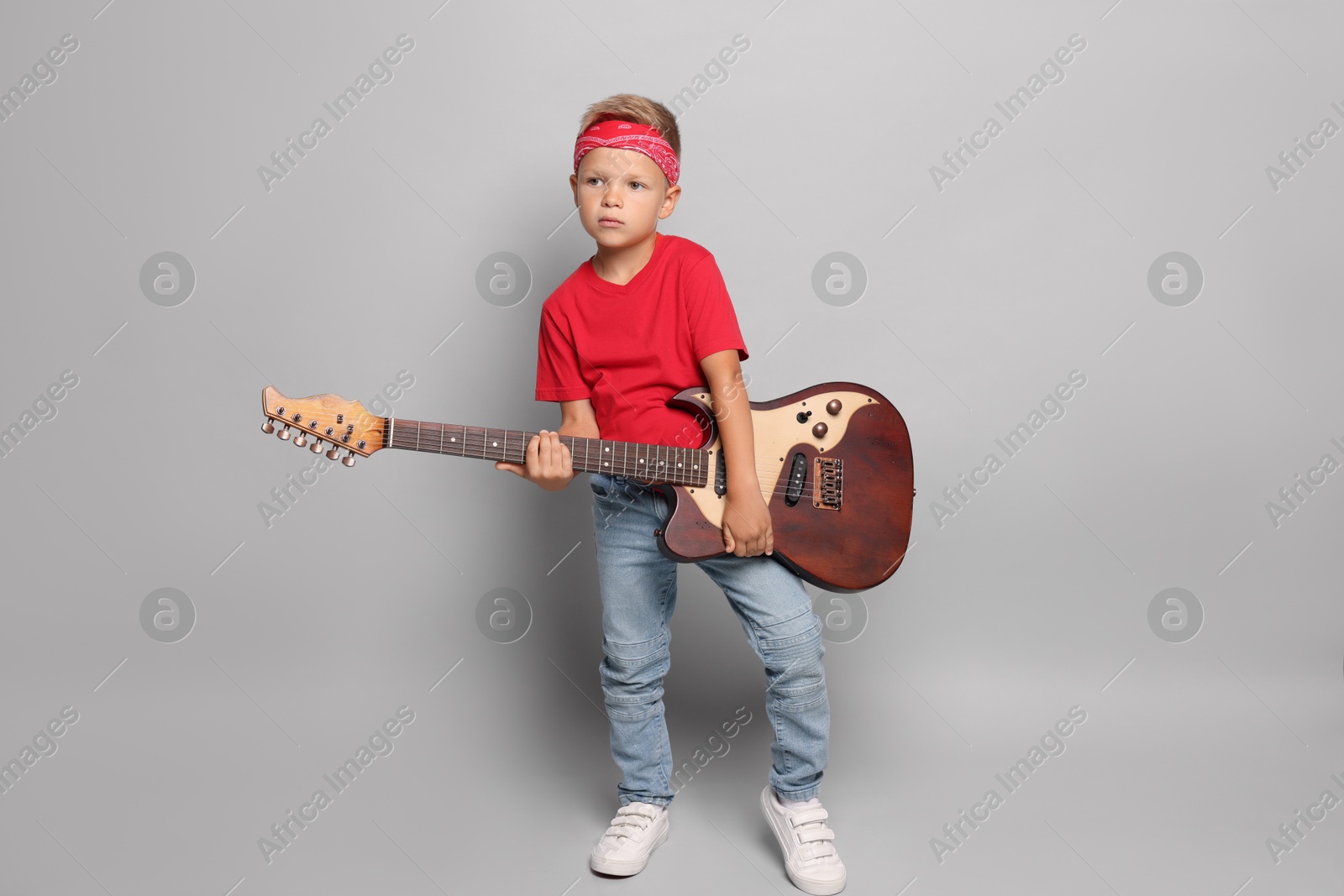 Photo of Little boy with guitar on light grey background