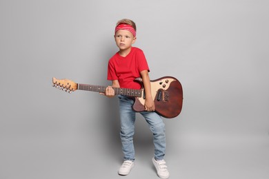 Photo of Little boy with guitar on light grey background