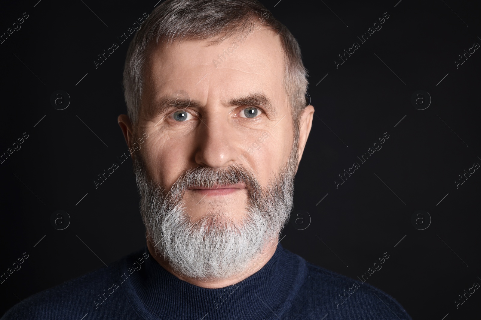 Photo of Portrait of senior man on black background