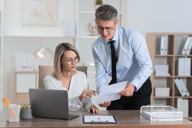 Photo of Middle aged employees working together in office