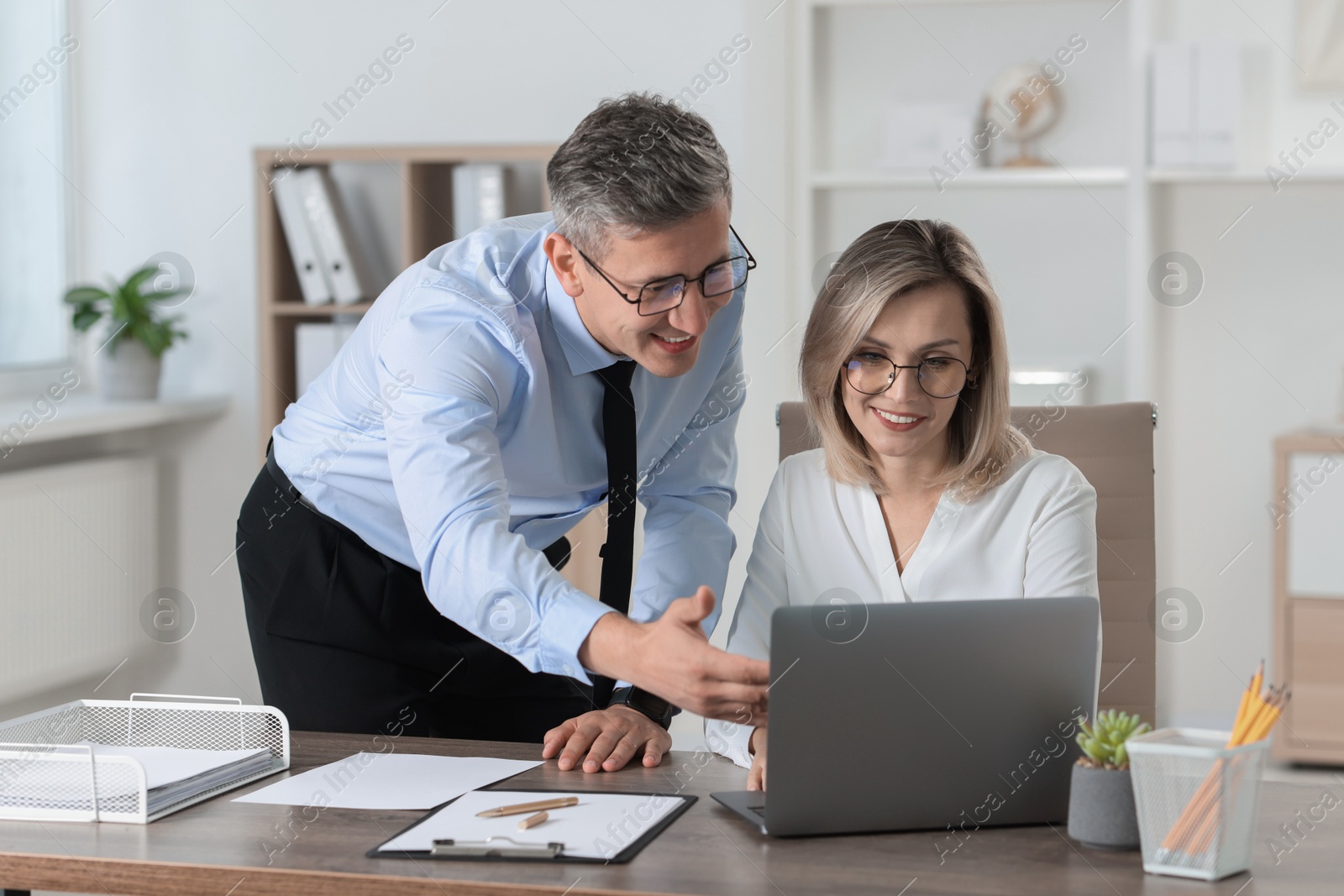 Photo of Middle aged employees working together in office