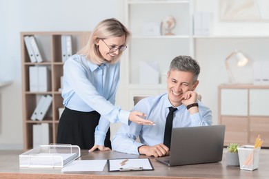 Photo of Middle aged employees working together in office