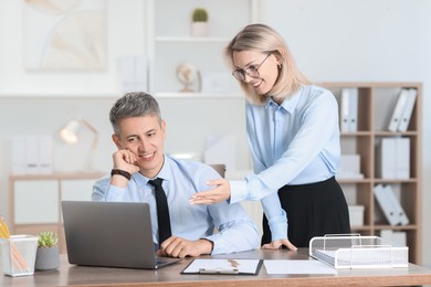 Photo of Middle aged employees working together in office