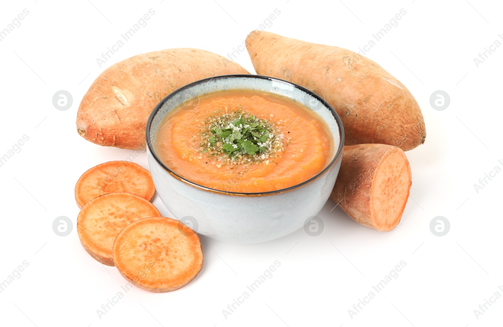 Delicious sweet potato soup in bowl and fresh vegetables isolated on white Photo of Delicious sweet potato soup in bowl and fresh vegetables isolated on white