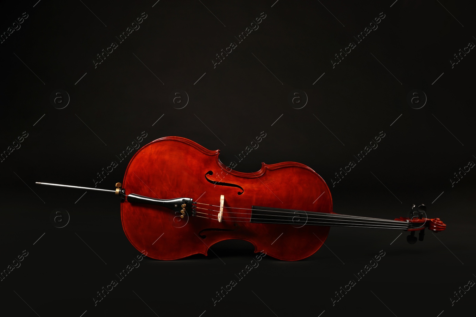 Photo of Beautiful cello on black background. Classic musical instrument