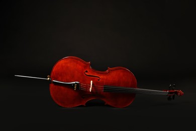 Photo of Beautiful cello on black background. Classic musical instrument