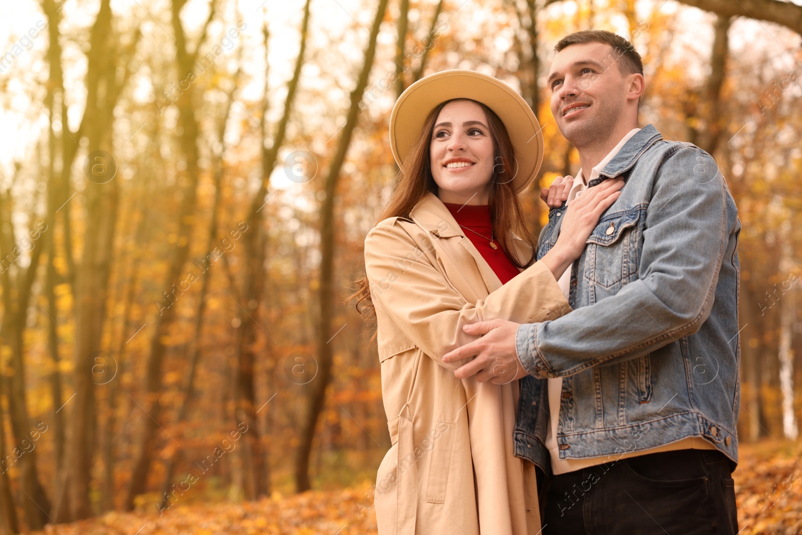 Photo of Happy couple spending time together in autumn park, space for text