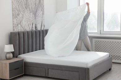 Photo of Woman changing clean bed linens at home