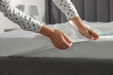 Photo of Woman changing clean bed linens at home, closeup