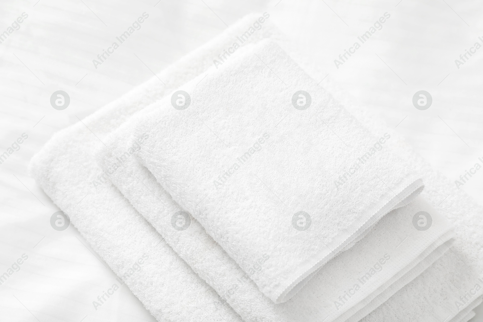 Photo of Stack of towels on clean linens indoors, closeup