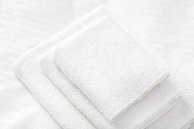 Photo of Stack of towels on clean linens indoors, closeup