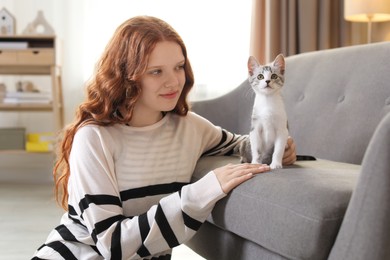 Photo of Beautiful teenage girl with cute cat at home