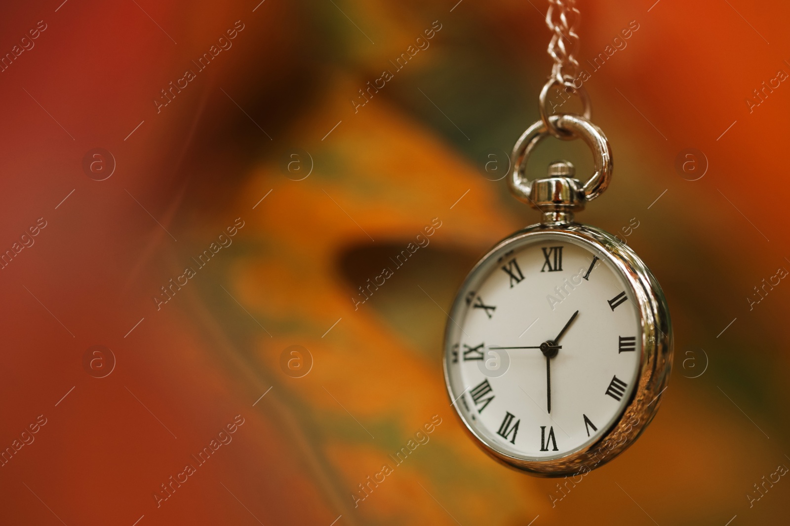 Photo of Autumn time. Chain watch on blurred background, closeup with space for text