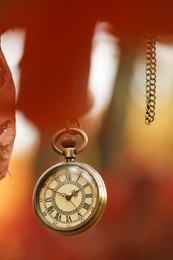 Photo of Autumn time. Chain watch hanging on tree in park, selective focus. Space for text