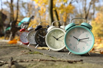 Photo of Alarm clocks on paved pathway in park at autumn