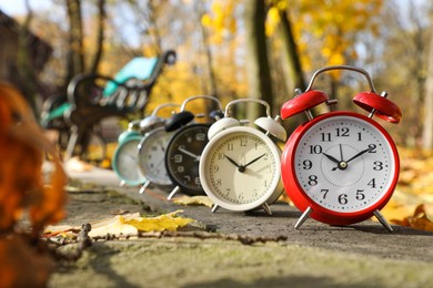 Photo of Alarm clocks on paved pathway in park at autumn