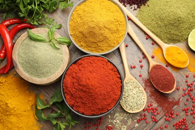 Photo of Different aromatic spices and herbs on wooden background, flat lay