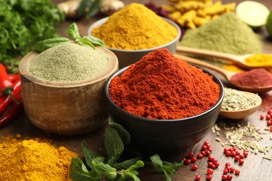 Different aromatic spices and herbs on wooden background, closeup