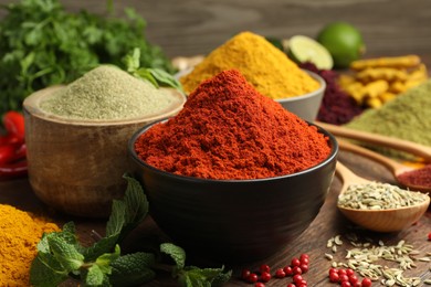 Photo of Different aromatic spices and herbs on wooden background, closeup