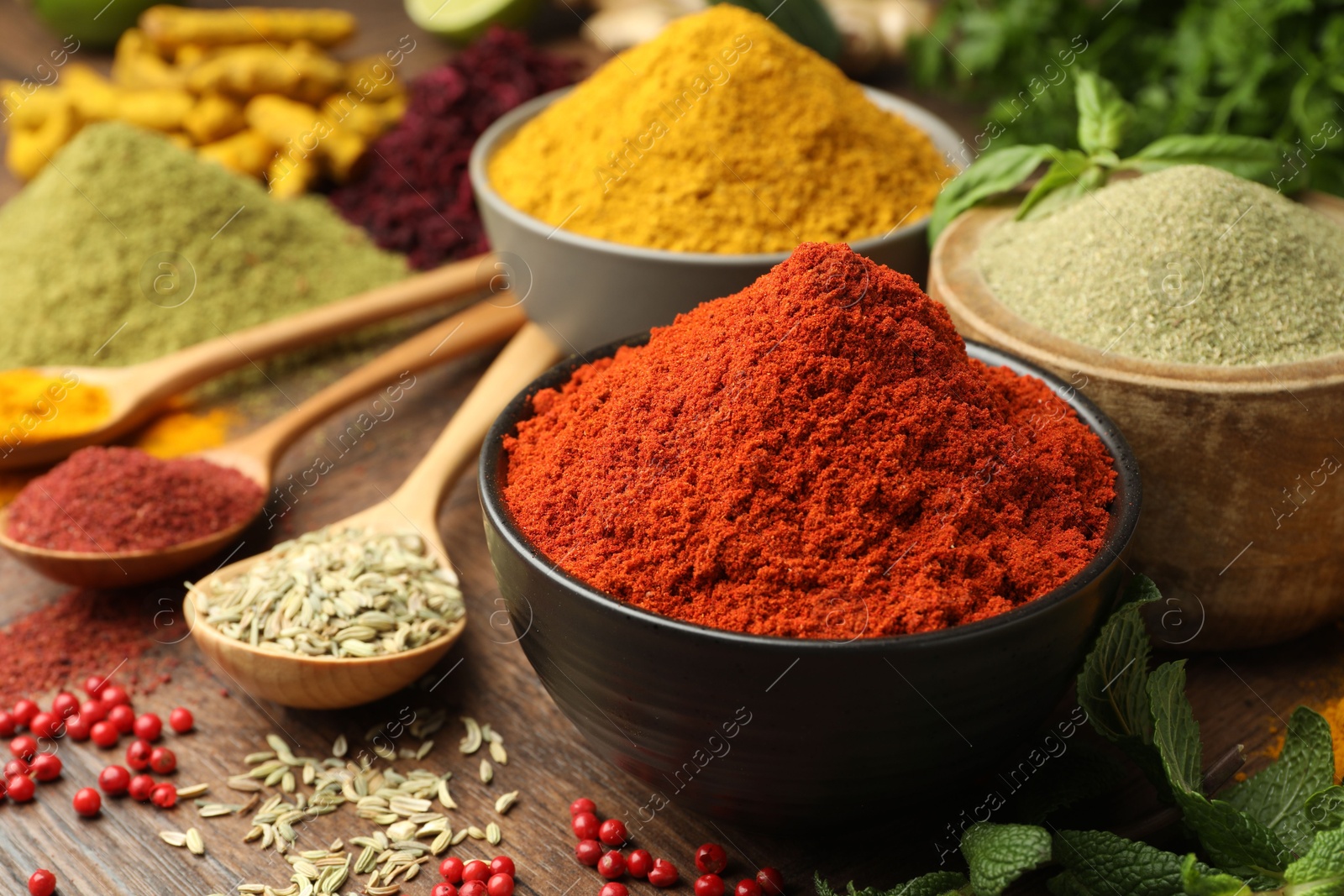 Photo of Different aromatic spices and herbs on wooden background, closeup