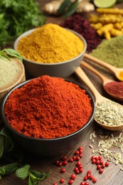 Photo of Different aromatic spices and herbs on wooden background, closeup