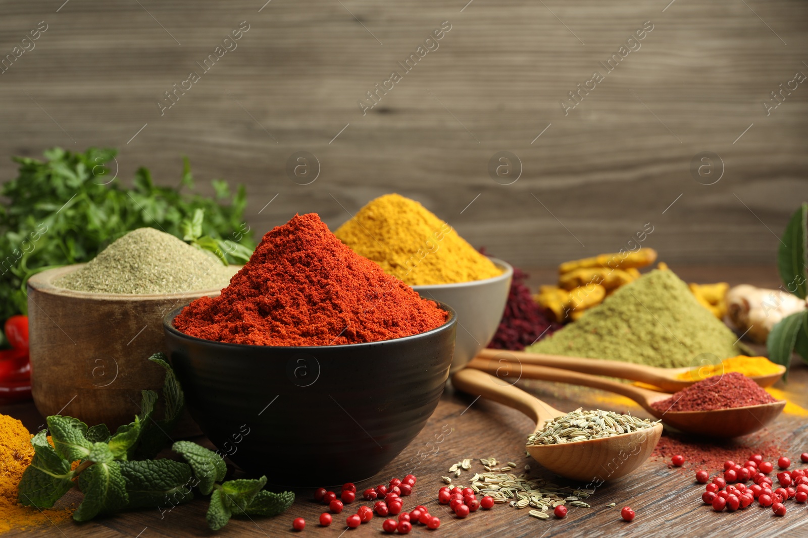 Photo of Different aromatic spices and herbs on wooden background, closeup