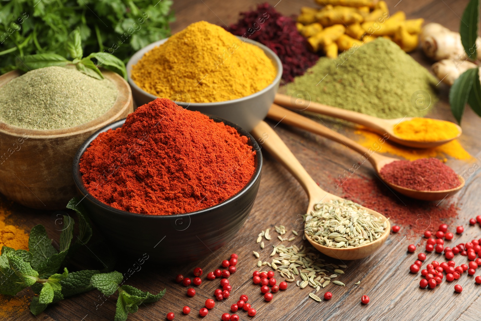 Photo of Different aromatic spices and herbs on wooden background, closeup