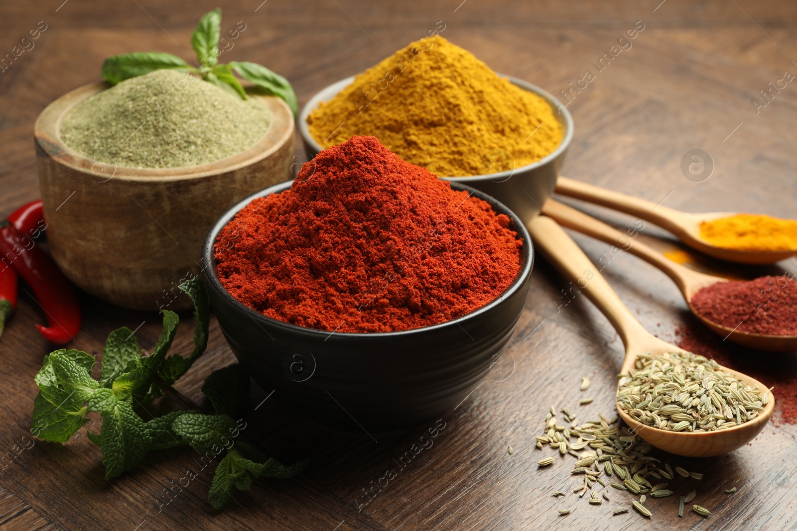 Photo of Different aromatic spices and herbs on wooden background, closeup