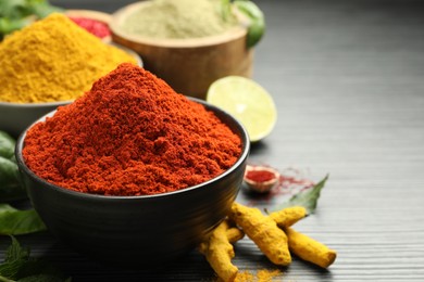 Different aromatic spices and herbs on black background, closeup