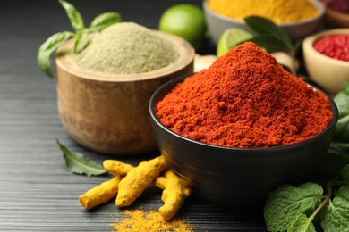 Photo of Different aromatic spices and herbs on black background, closeup