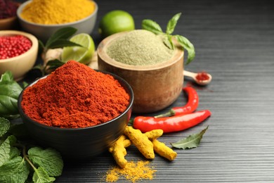 Photo of Different aromatic spices and herbs on black background, closeup. Space for text