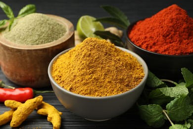 Different aromatic spices and herbs on black background, closeup