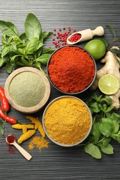 Different aromatic spices and herbs on black background, flat lay