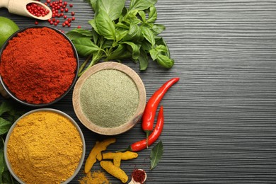 Different aromatic spices and herbs on black background, flat lay