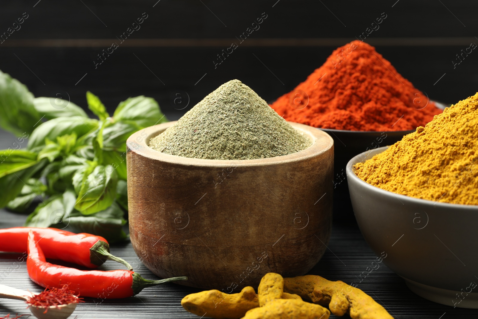 Photo of Different aromatic spices and herbs on black background, closeup