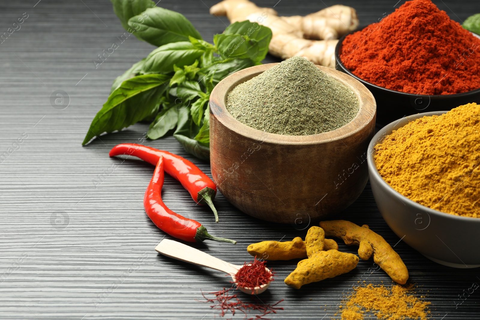 Photo of Different aromatic spices and herbs on black background, closeup