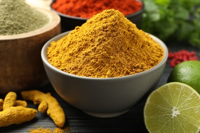 Photo of Different aromatic spices, lime and herbs on black background, closeup