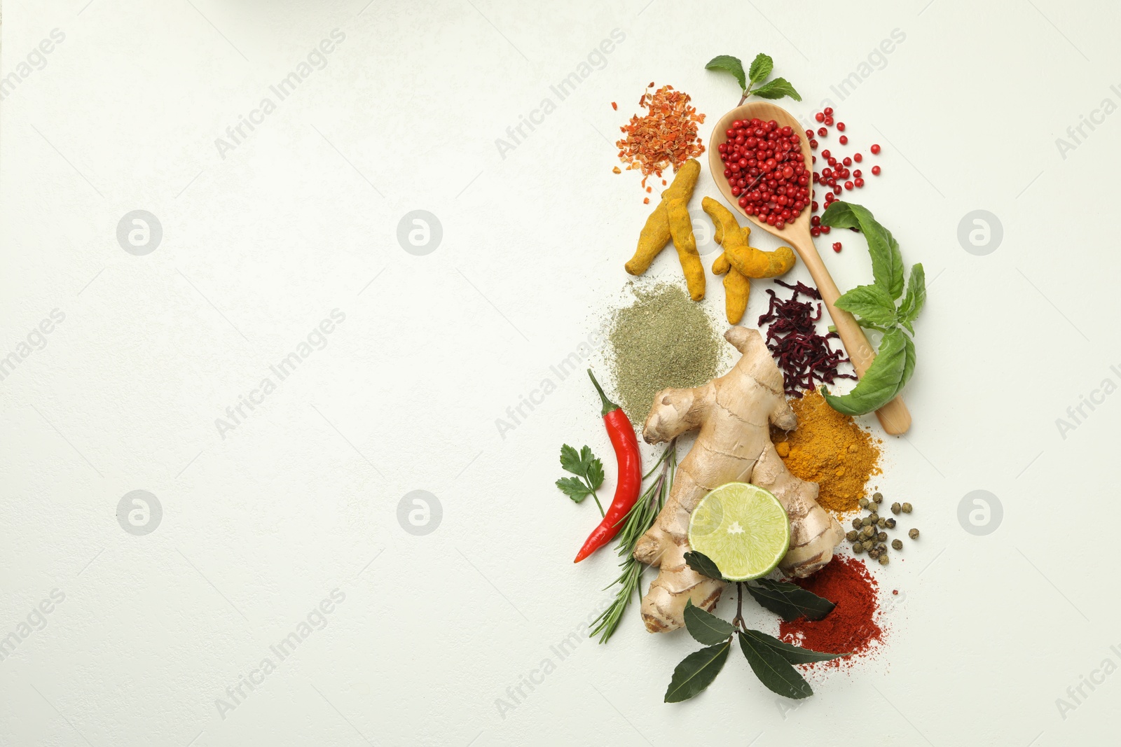 Photo of Different aromatic spices, lime and herbs on white background, flat lay. Space for text