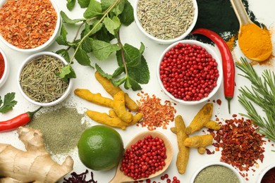 Different aromatic spices, lime and herbs on white background, flat lay