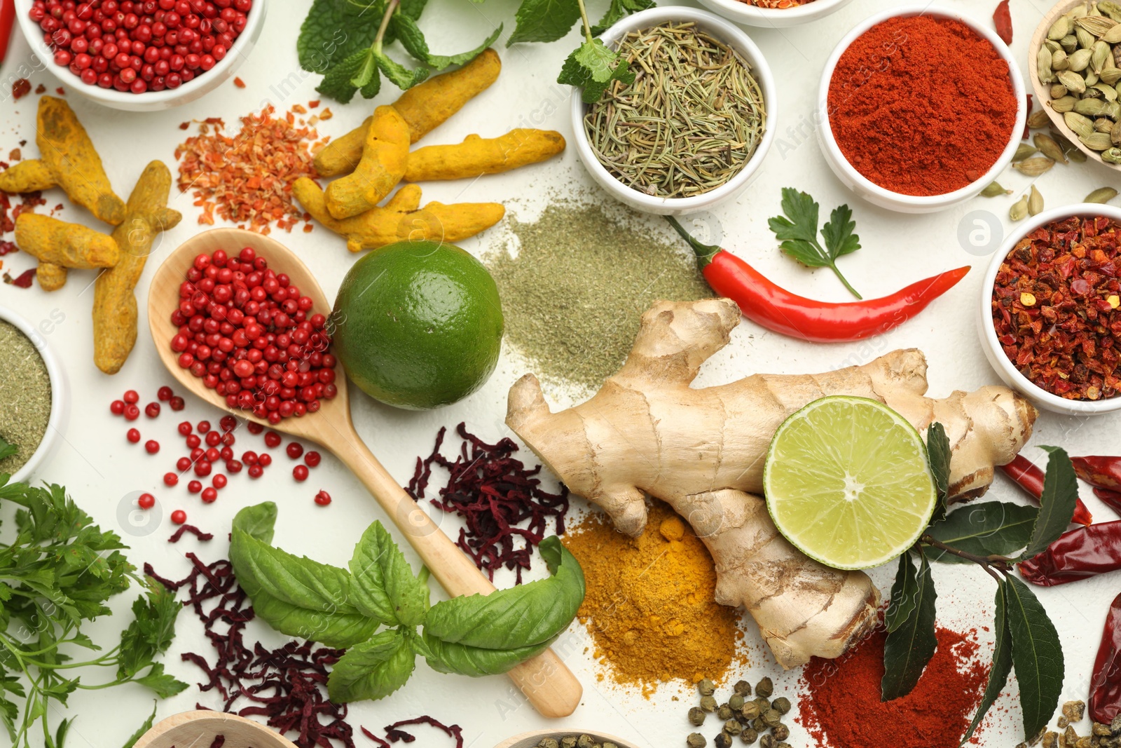 Photo of Different aromatic spices, lime and herbs on white background, flat lay