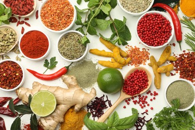 Different aromatic spices, lime and herbs on white background, flat lay